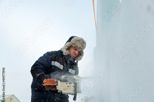 Worker cuts ice panel with gasoline saw