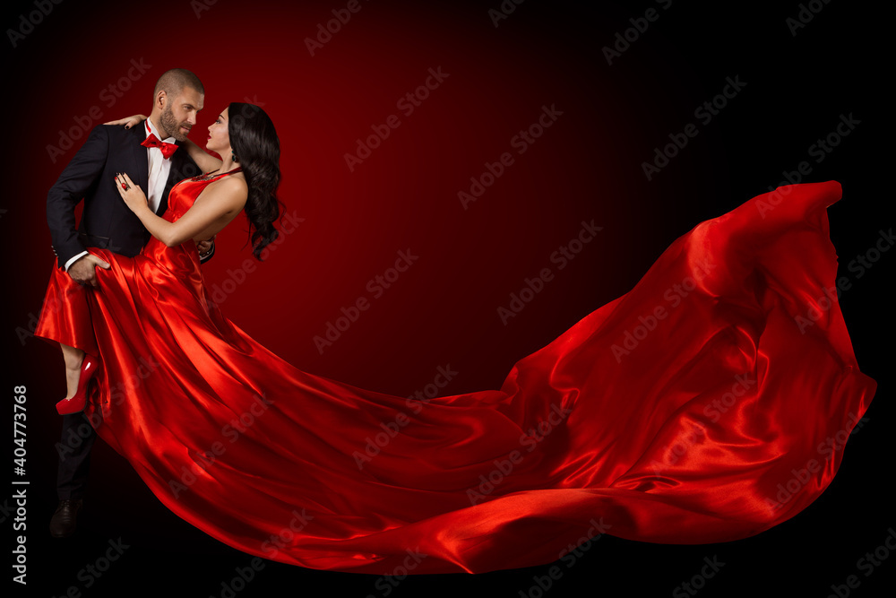 Fototapeta Happy Dancing Couple Portrait, Woman in Red Silk Gown and Handsome Beard Man in Suit, Flying Waving Fabric
