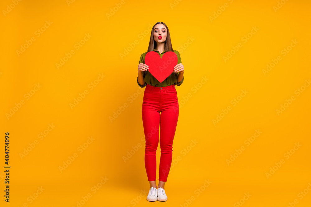 Fototapeta premium Full length body size view of nice straight-haired girl holding in hands heart sending air kiss isolated on bright yellow color background