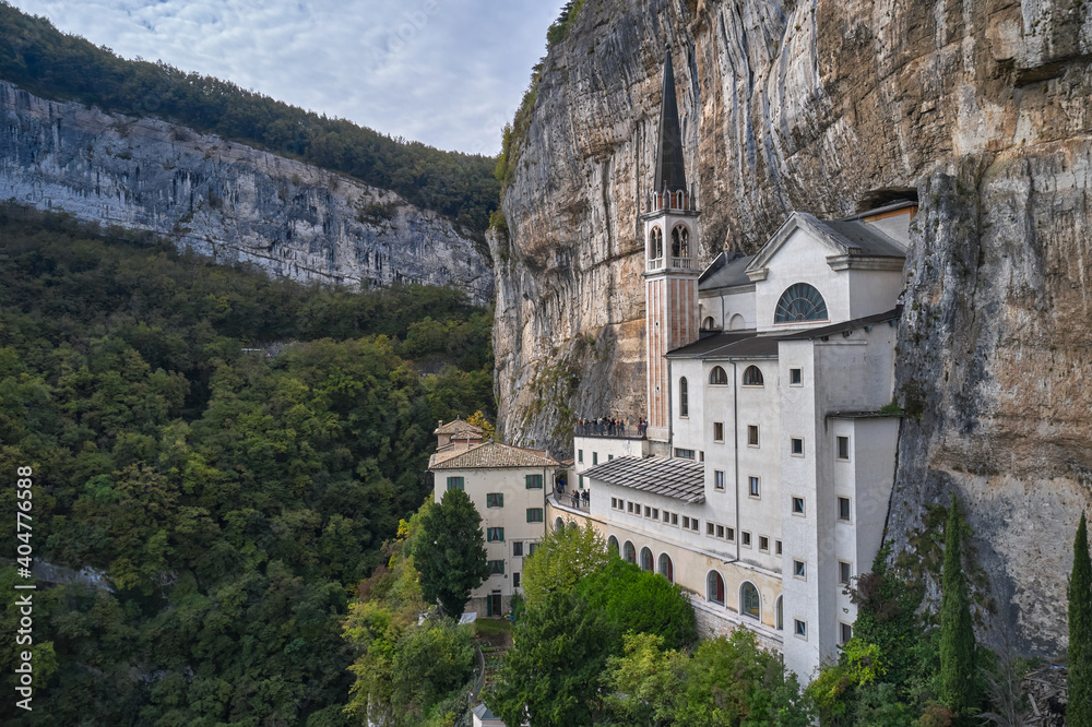 The unique Sanctuary Madonna della Corona church in the rock.The sanctuary is high in the mountains of Italy. Aerial view of the church on the sheer cliff. Italian church at high altitude in the Alps