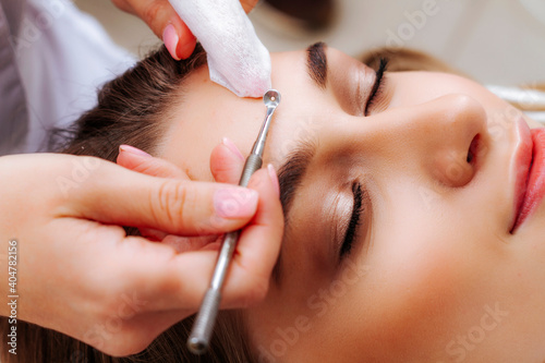 Mechanical face cleansing by a beautician. Problem skin treatment. Cosmetologist and patient.