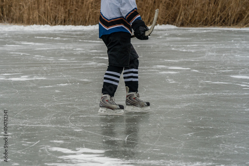 Close-up of hockey player and stick on frozen lake