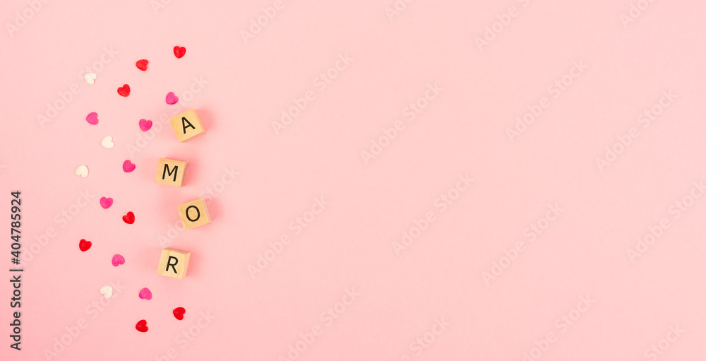 Word AMOR on wooden cubes in a pink background. Copy space.