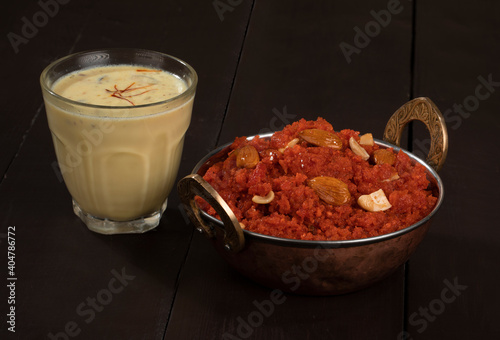 Indian Special Famous Winter Sweet Food Carrot Halwa or Gajar ka Halwa Served With Kesar Masala Milk  photo