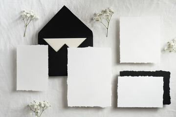 Elegant wedding stationery top view. Flat lay blank paper card, envelopes, flowers on white background.