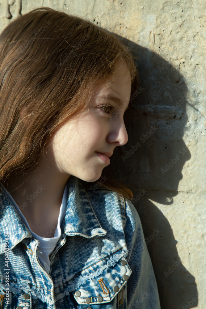 teenage girl in profile near a concrete wall teenage girl in profile near a concrete wall