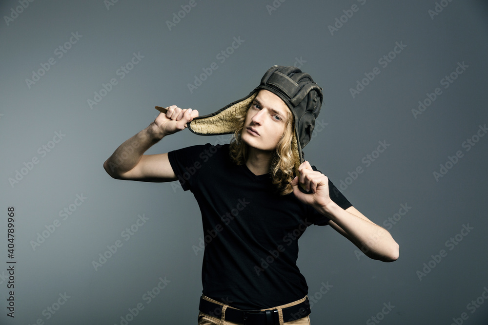 Young guy model posing in a tankman helmet. A portrait of a man Young guy model posing in a tankman helmet. A portrait of a man
