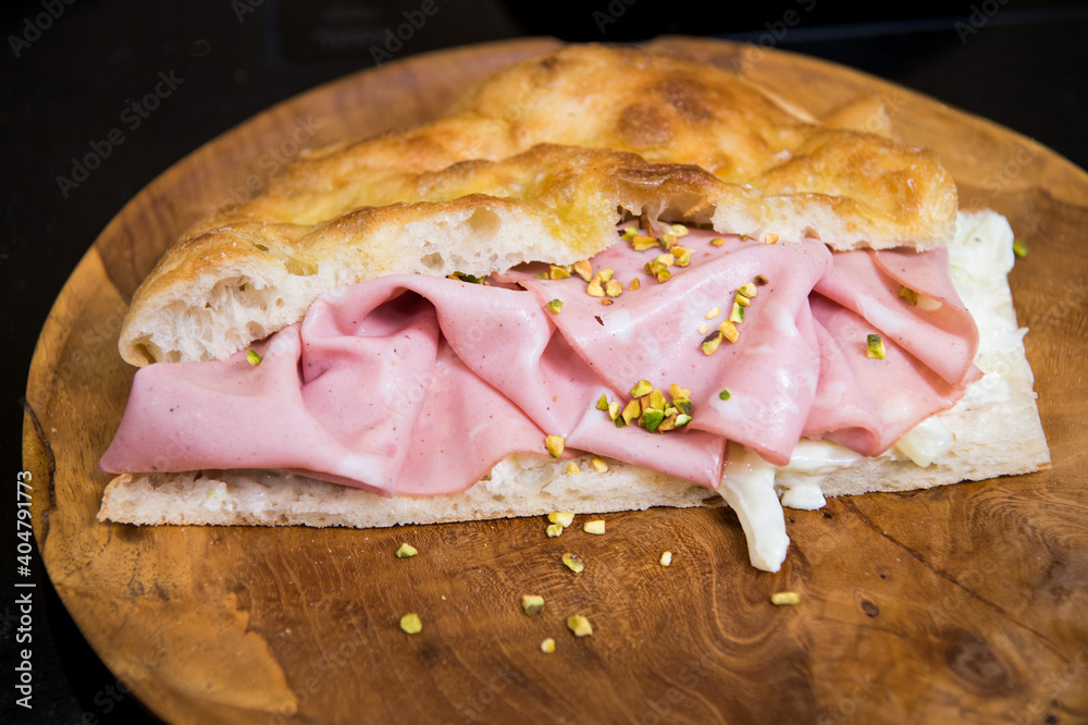 Φωτογραφία Mortadella Bologna is a large Italian sausage made with cooked pork, mixed with cubes of cylindrical or oval-shaped pork fat