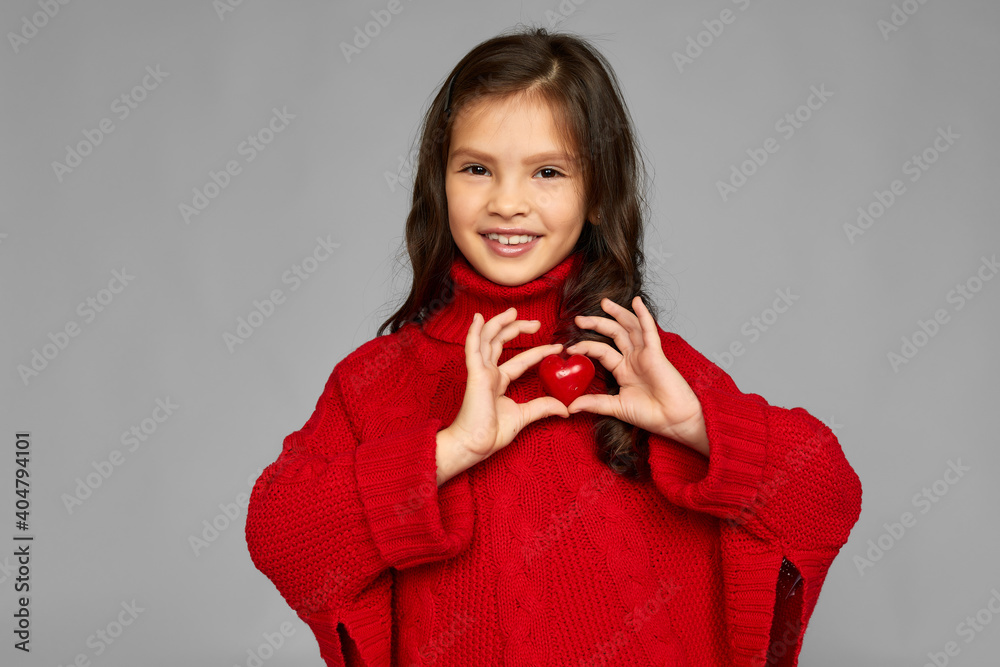 portrait of happy child girl holding red heart isolated on gray background. valentine's day. portrait of happy child girl holding red heart isolated on gray background. valentine's day.