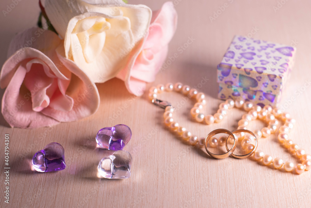 Wedding preparations. Two wedding rings, pearl beads, flowers and hearts. The photo Wedding preparations. Two wedding rings, pearl beads, flowers and hearts. The photo