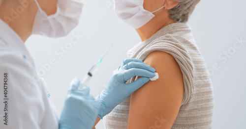 Cuadro en lienzo Doctor giving a senior woman a vaccination