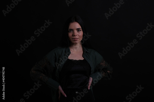 Portrait of beautiful young brunette woman on black background