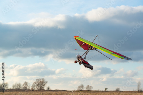 Brave girl learn to fly on the colorful hang glider wing. photo