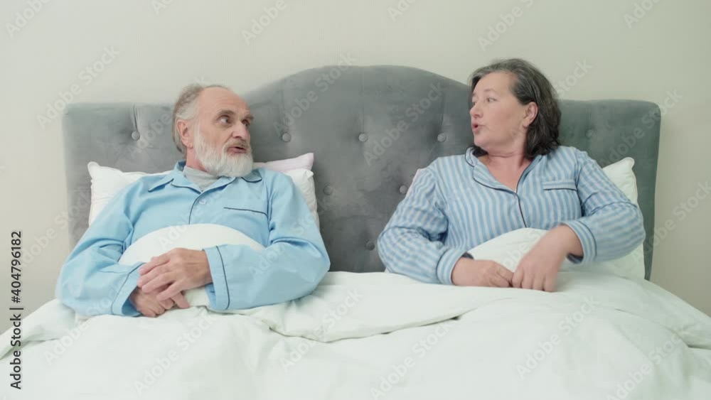 Elderly man and woman arguing in bed, couple misunderstanding, family crisis Elderly man and woman arguing in bed, couple misunderstanding, family crisis