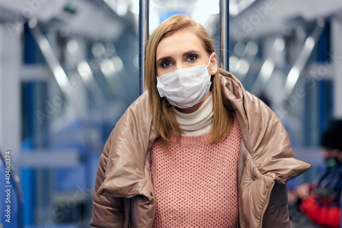 Woman in metro station wearing protective surgical hygiene mask on face prevent from risk of coronavirus