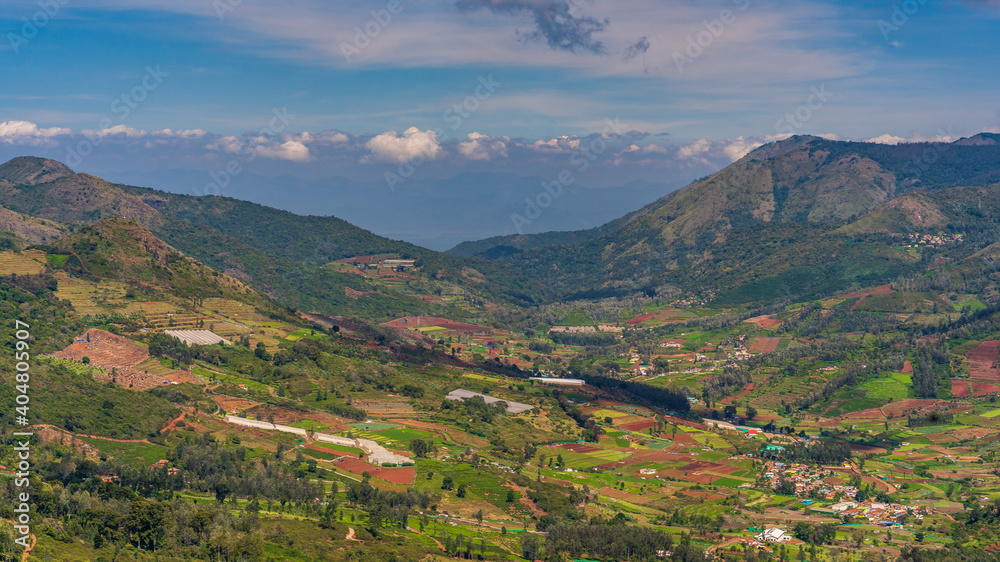 Obraz premium ooty village of green mountains landscape with sky and clouds . Ooty or Ootacamund or Udhagamandalam is a popular hill station in India