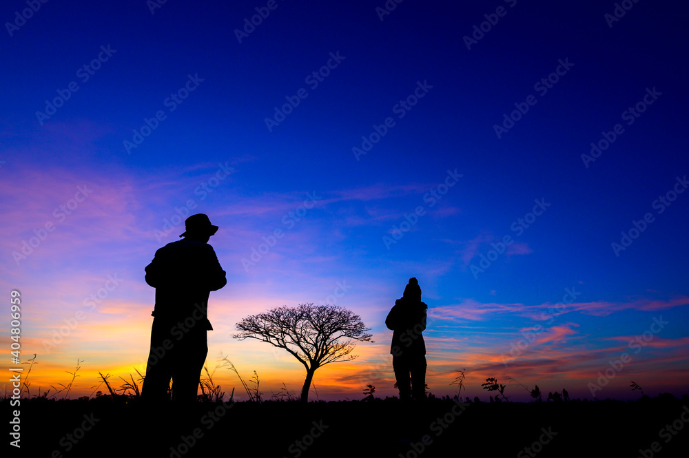 Fototapeta premium silhouetted people on open field sunset