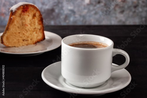 Cup of coffee with cream with a slice of freshly baked homemade muffin