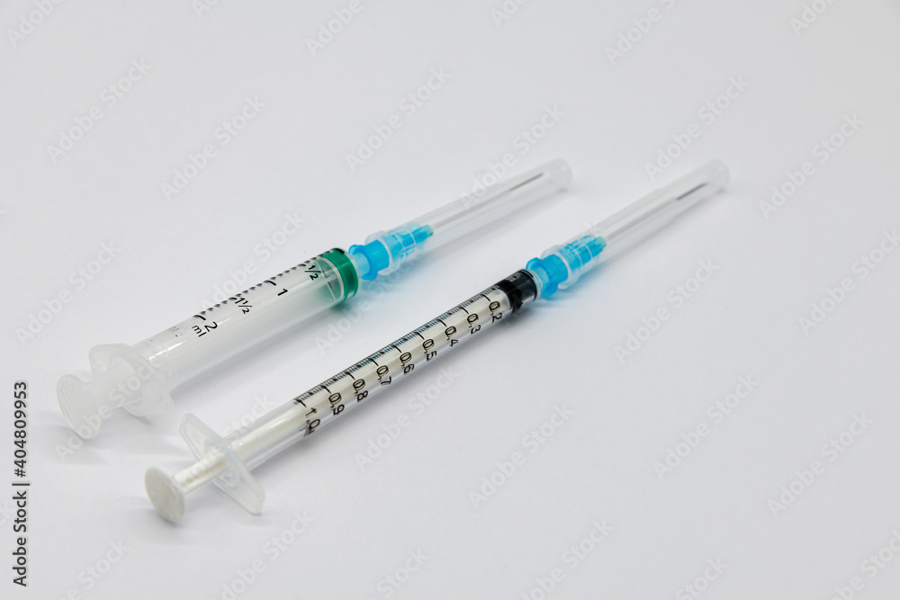 Medical syringes and needles for hypodermic injection on a marble counter top. The syringe and needle are capped. Medical syringes and needles for hypodermic injection on a marble counter top. The syringe and needle are capped.