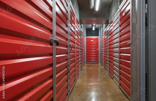 Storage corridor warehouse. Self storage facility, red metal doors with locks. Moving, organizing, storage concept.  photo