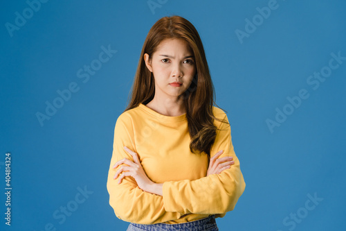 Young Asia lady with negative expression, excited screaming, crying emotional angry in casual clothing and looking at camera isolated on blue background. Happy adorable glad woman rejoices success.