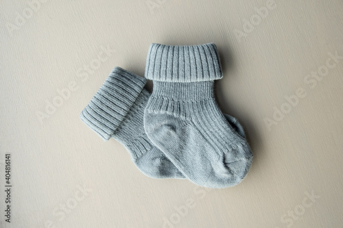 A pair of small baby, new born socks on wooden background. Happy birthday, baby shower idea.