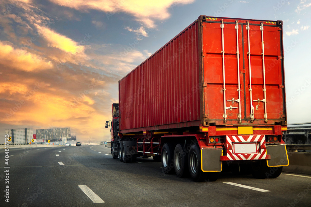 image motion blur.Truck on highway road with red container, transportation concept.,import,export logistic industrial Transporting Land transport on the asphalt expressway with sunrise sky. image motion blur.Truck on highway road with red container, transportation concept.,import,export logistic industrial Transporting Land transport on the asphalt expressway with sunrise sky.