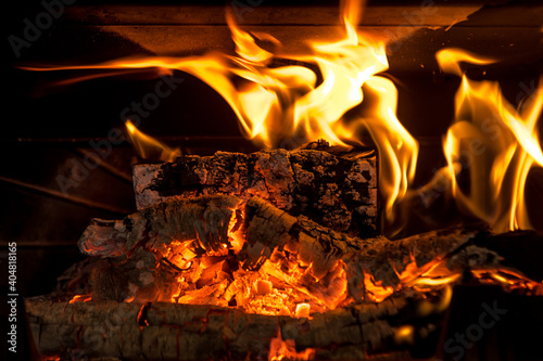 Logs burning in the fire of a fireplace with embers