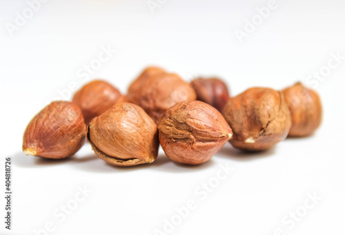 Several hazelnuts without shells close-up on a white background.