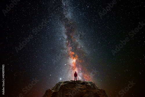 Człowiek na szczycie góry obserwujący wszechświat