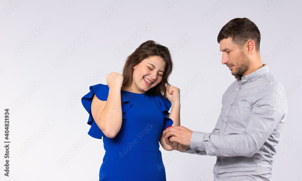 The satisfied girl waited for proposal of a hand and heart from her beloved man. Gray background. The satisfied girl waited for proposal of a hand and heart from her beloved man. Gray background.