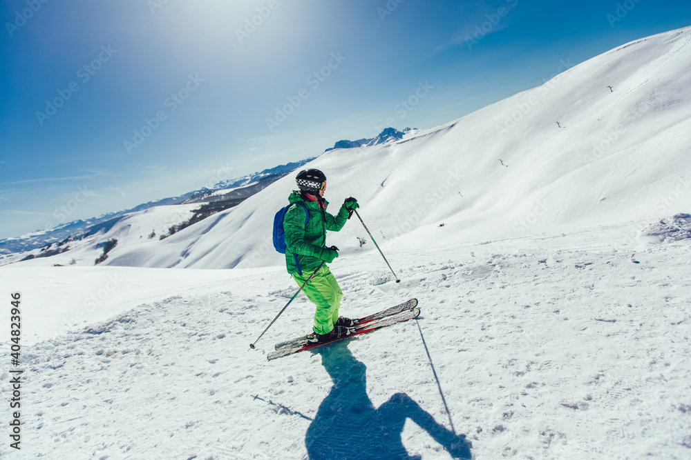 Young athlete freestyle Skier having fun while running downhill in beautiful landscape on sunny day during winter season Young athlete freestyle Skier having fun while running downhill in beautiful landscape on sunny day during winter season