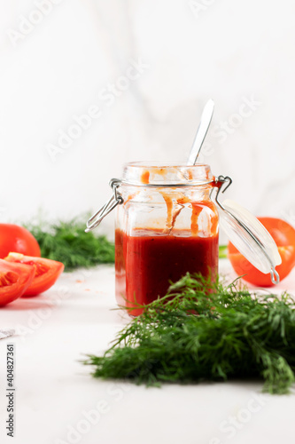  Homemade ketchup with tomatoes, paprika and garlic. A can of tomato sauce with fresh tomato and dill