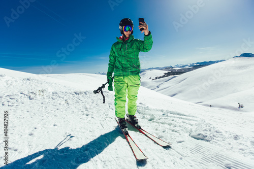Young athlete freestyle Skier having fun while running downhill in beautiful landscape on sunny day during winter season