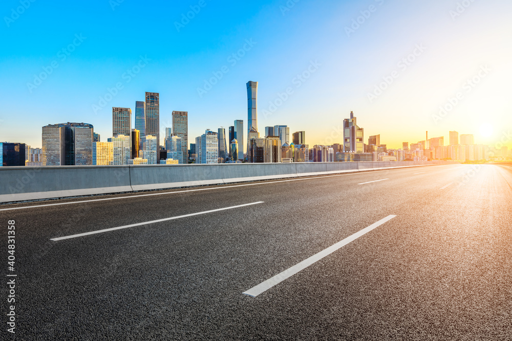 Asphalt road and modern city commercial buildings in Beijing at sunrise,China.