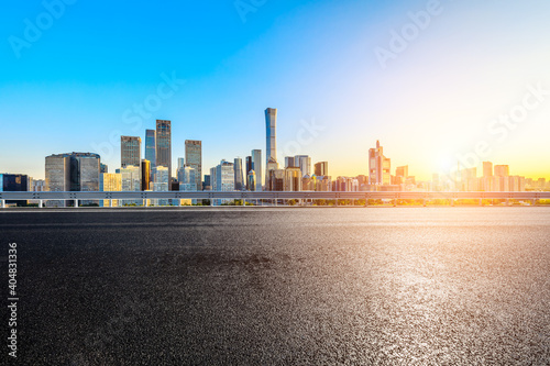 Asphalt road and modern city commercial buildings in Beijing at sunrise,China.