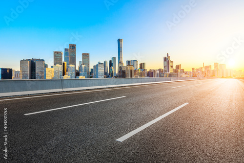 Asphalt road and modern city commercial buildings in Beijing at sunrise China.