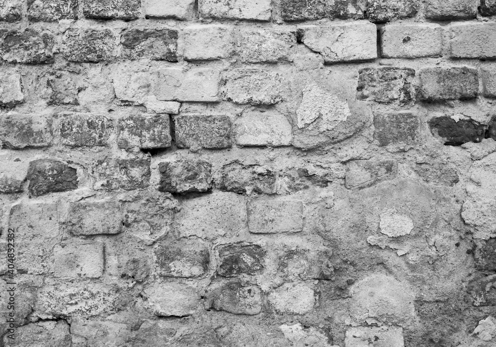 Obraz premium Gray brick wall background, old brick wall partly covered by concrete.