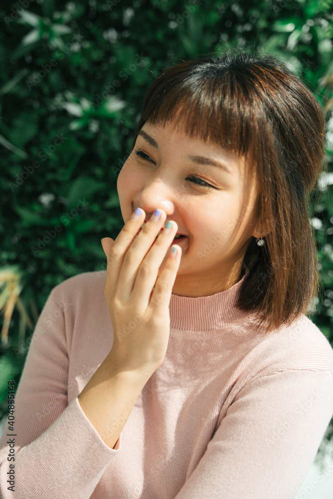 Close up - Beautiful asian thai woman wearing pink shirt standing outdoor in sunlight. Close up - Beautiful asian thai woman wearing pink shirt standing outdoor in sunlight.