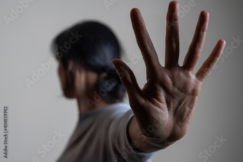 Woman rises her hand up and showes stop gesture by hand trying to stop any coming danger. Nonverbal language sign photo