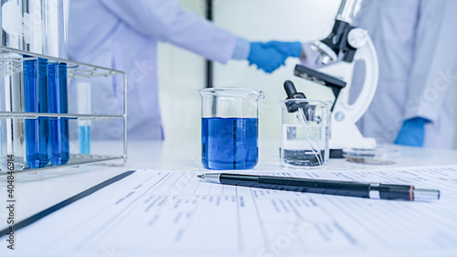 Medical or scientific researcher or man doctor looking at a test tube of clear solution in a laboratory