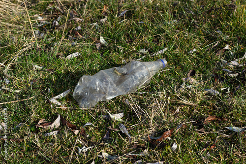 environmental pollution concept, old plastic bottle among grass