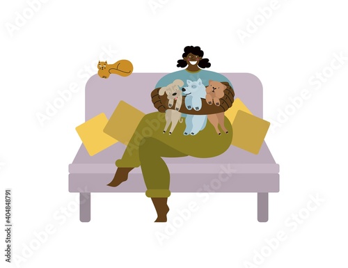 African girl dogsitter sitting on the couch with a cat and a pug, husky, mongrel.