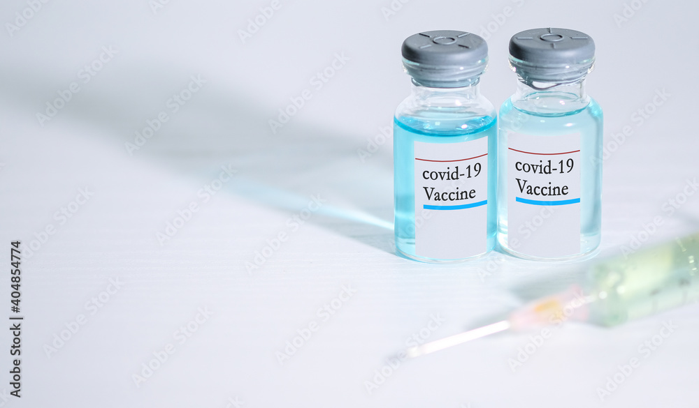 Coronavirus COVID-19 concept. blue liquid in vaccine vials and Syringe on white background and copy space for text