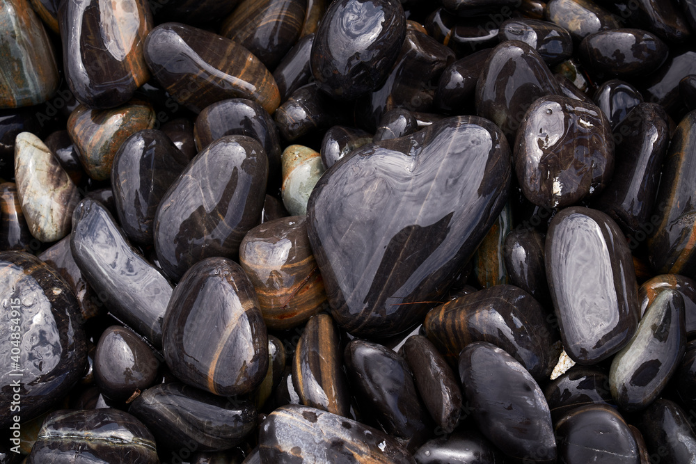 Wet stone heart shape pattern on ground in islands background Wet stone heart shape pattern on ground in islands background