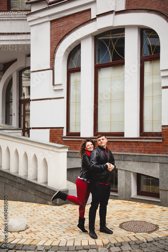 rock style couple in the old City. Happy lovers on the walk outside. Funny couple pair weared in black leather jackets. Romantic walk for young happy family.  © Olga Mishyna