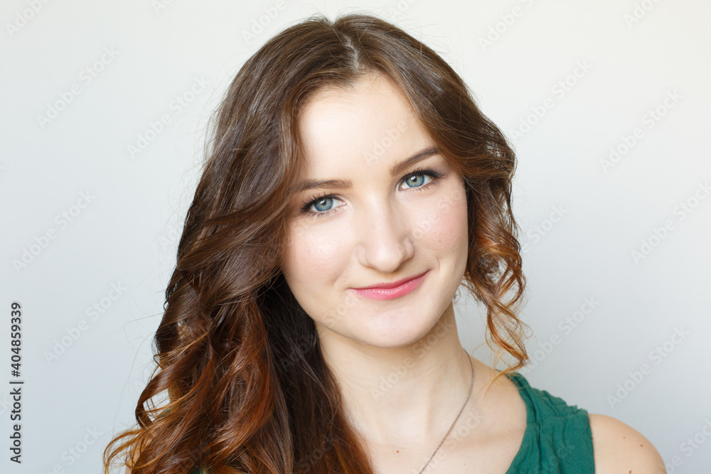 Young brown-haired girl portrait. Fresh makeup. White background. Studio photo. Happy elegant lady. Curled hairstyle Young brown-haired girl portrait. Fresh makeup. White background. Studio photo. Happy elegant lady. Curled hairstyle