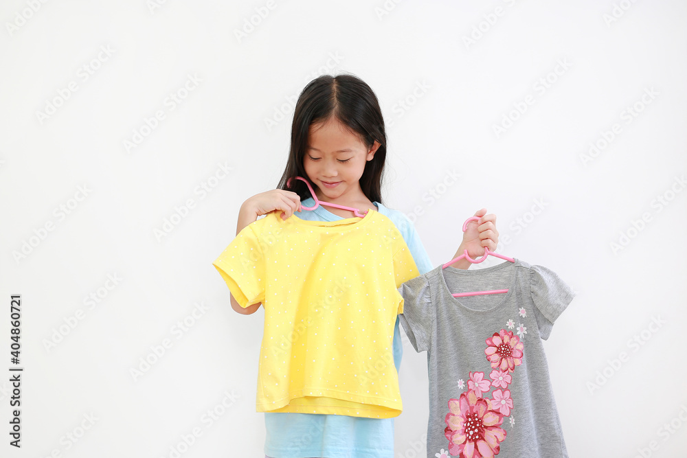 Little asian child choosing clothes on white background Little asian child choosing clothes on white background