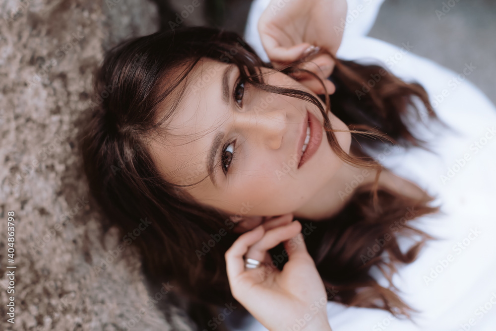 Fototapeta premium Portrait of beautiful young woman with natural makeup in fashion casual clothes resting in nature
