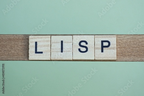 gray word lisp made of wooden square letters on green background